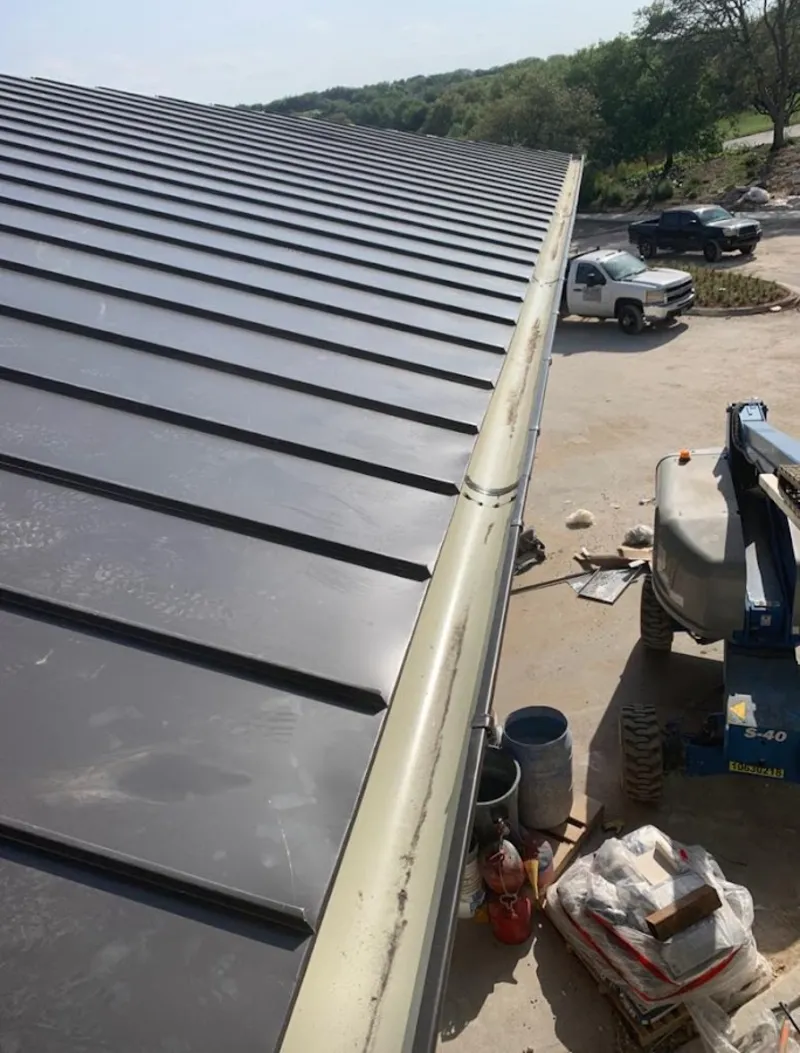 Standing seam panel and gutter detail on a metal roofing jobsite in Muscoy